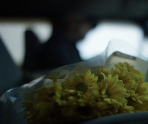 Close up of flowers on the passenger seat next to dad driving the truck.