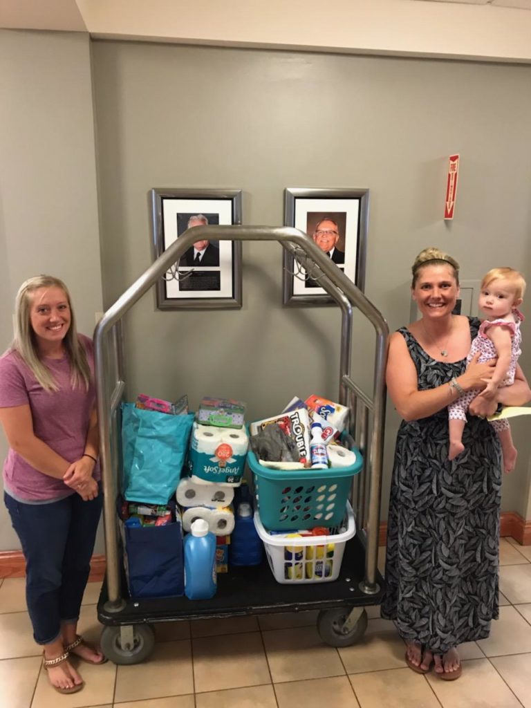 Mauro family in main lobby pose with a cart full of donated items