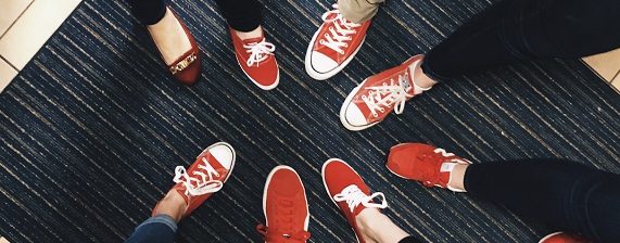 Red Shoe members form a circle and step one foot in for a photo taken from above.