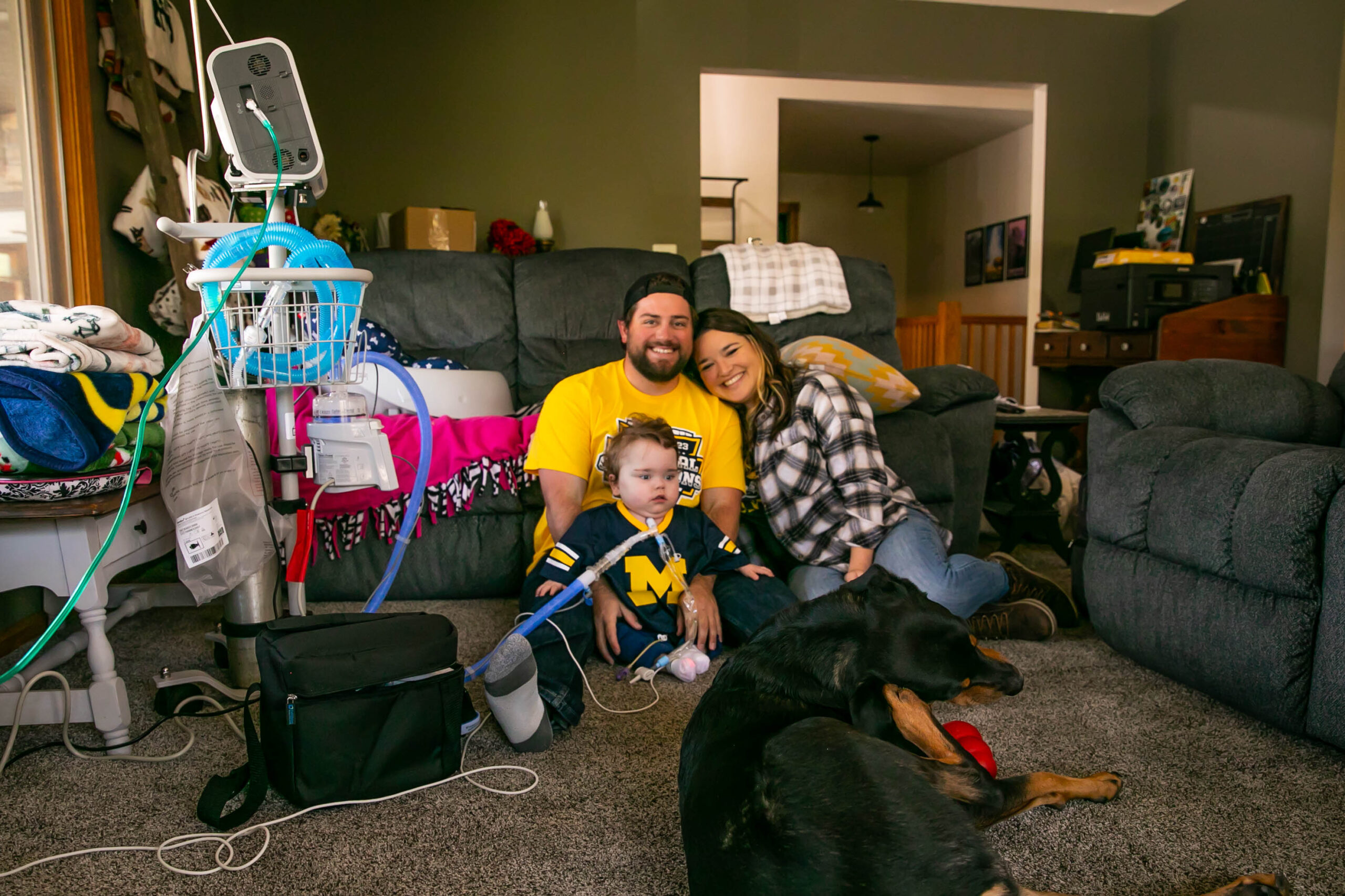 A mom, dad and son at home with their dog